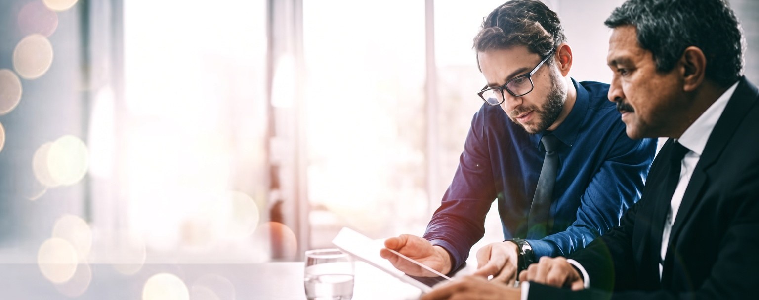 Dois executivos analisando um relatório em reunião
